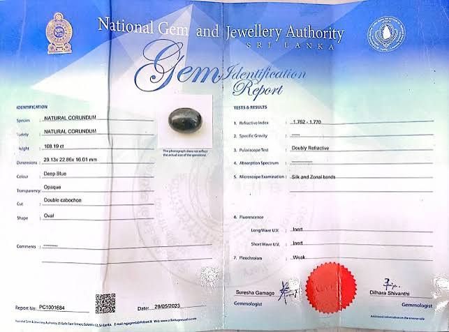 NGJA grading report and gemstone under laboratory conditions