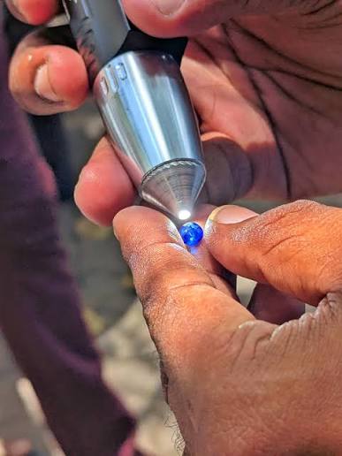 Independent gemologist inspecting a stone under a loupe before grading